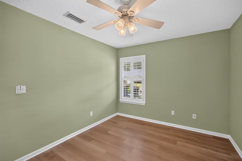 Bedroom with green walls and closet doors at 2131 E Stone Creek Dr, Fleming Island, FL