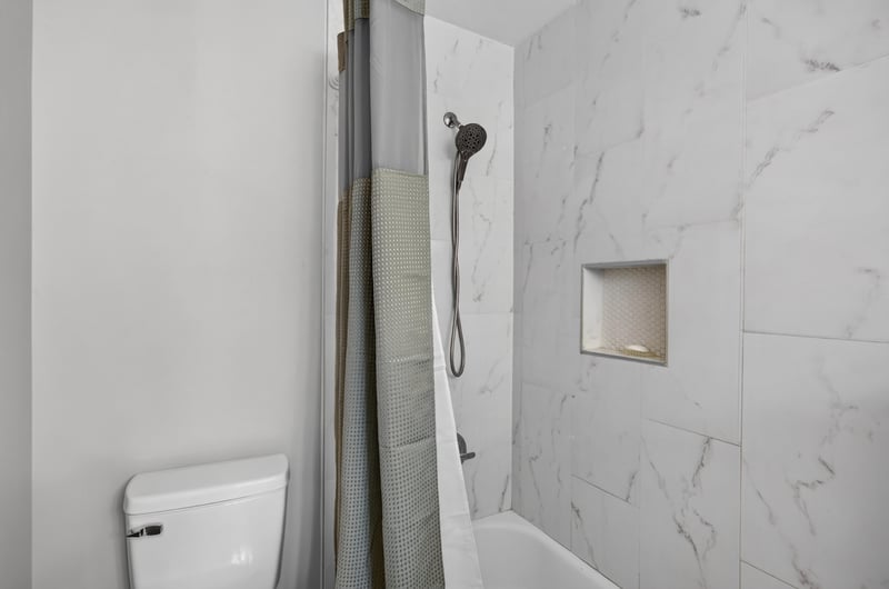 Walk-in shower with marble-look tile at 9506 Harriet Ave, Jacksonville, FL 32208