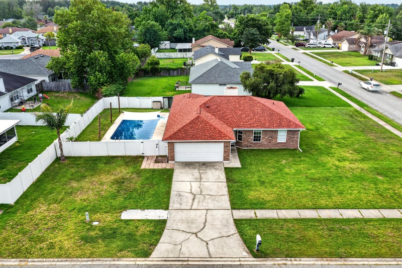 Aerial angled view of the home, pool, and street at 2164 Orangewood St, Middleburg, FL 32068