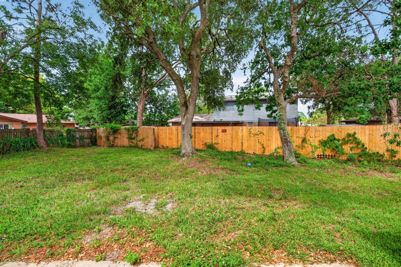Backyard with trees and fenced border at 9954 Larkdale Ct, Jacksonville, FL 32257