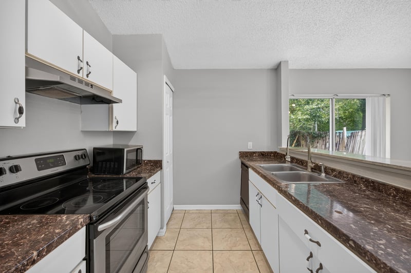 Kitchen with dark granite counters and stainless appliances at 7329 Lawn Tennis Ln, Jacksonville, FL