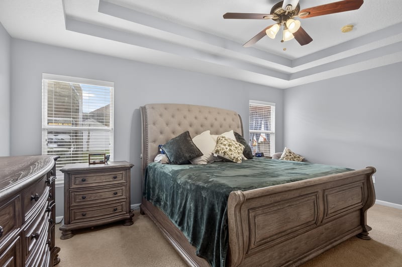 Primary bedroom with sleigh bed and tray ceiling at 3112 Silverado Cir, Green Cove Springs, FL 32043
