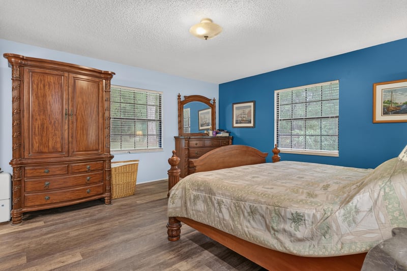 Primary bedroom with blue walls and wood dresser at 3249 Maryland Ave, Green Cove Springs, FL