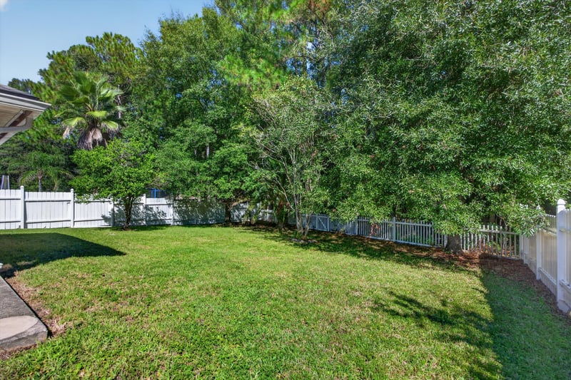 Backyard lawn with trees and fence line at 14147 Fish Eagle Dr E, Jacksonville, FL 32226