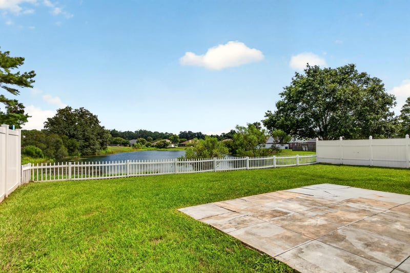 Backyard view toward pond and fence line at 490 Hillside Dr, Orange Park, FL 32073