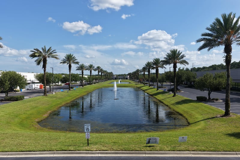 Pond with fountain beside palm-lined parking area at 10550 Deerwood Park Blvd, Jacksonville, FL 32256
