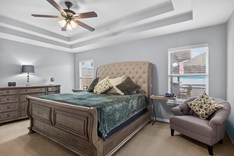 Primary bedroom with ceiling fan and accent chair at 3112 Silverado Cir, Green Cove Springs, FL 32043