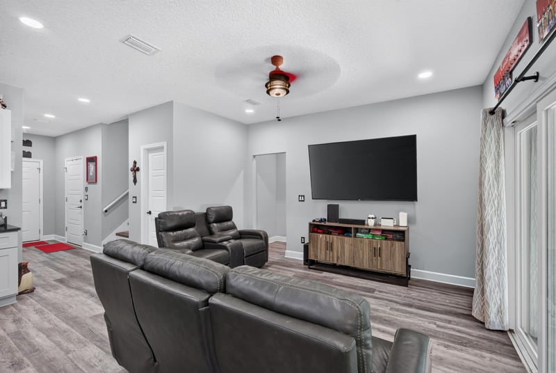 Living room with television and wood-look flooring at 2817 Camel Cir, Middleburg, FL