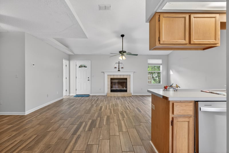 Living room with fireplace and wood-look flooring at 2164 Orangewood St, Middleburg, FL 32068