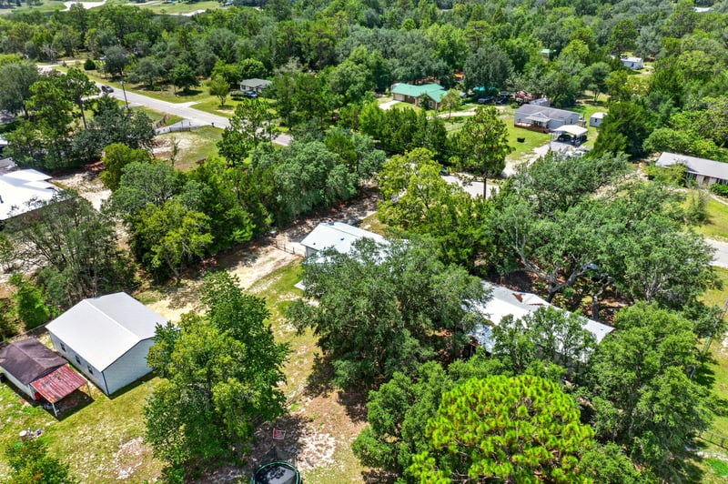 Aerial view of wooded lot with outbuildings in Keystone Heights, FL