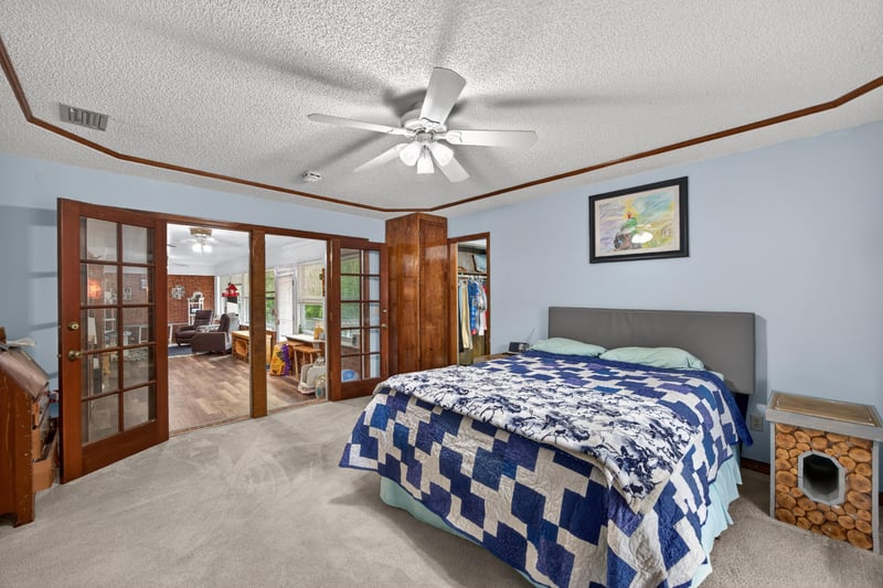 Primary bedroom with French doors and ceiling fan at 981 Marble Ridge Dr, Orange Park, FL 32065