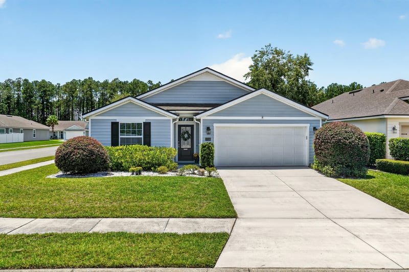 Front exterior view with garage and landscaped yard at 10066 Andean Fox Dr, Jacksonville, FL 32222