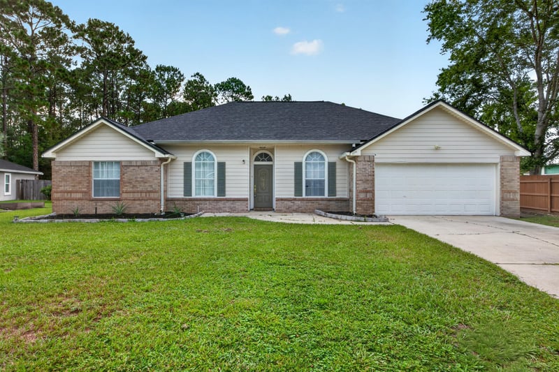 Front exterior with brick accents and landscaping at 8921 Needlepoint Pl, Jacksonville, FL 32244