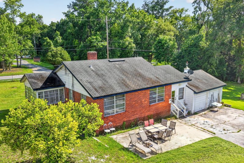 Side exterior with screened porch and patio furniture at 5745 110th St, Jacksonville, FL 32244