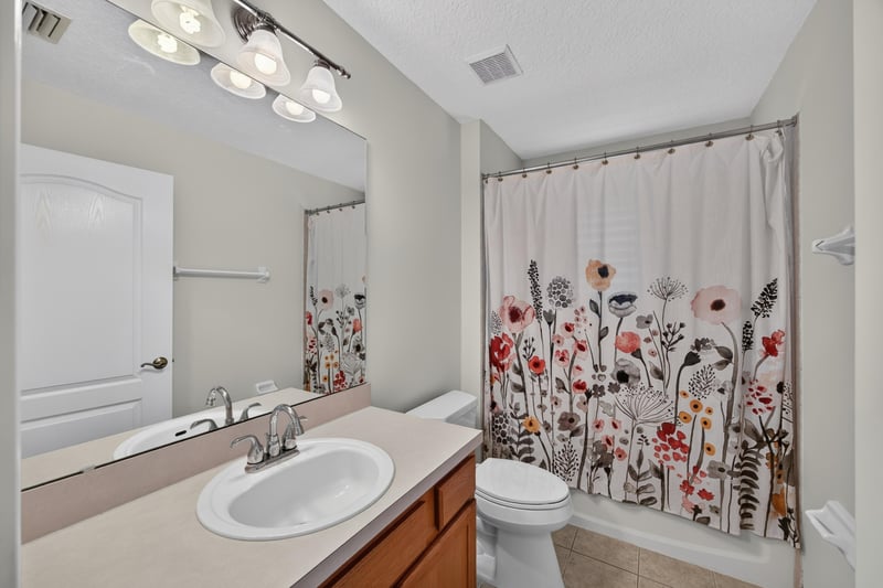Bathroom with floral shower curtain and vanity at 2131 E Stone Creek Dr, Fleming Island, FL