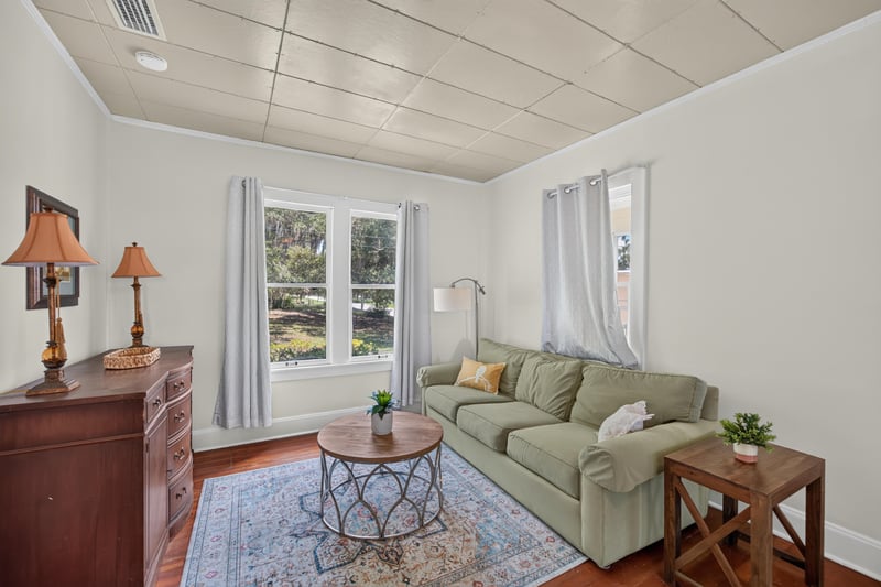 Living room with green sofa and wood floors at 101 N Lake St, Crescent City, FL