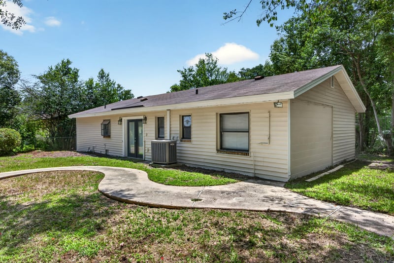Rear exterior view of home with lawn and walkway at 7453 Jade Dr N, Jacksonville, FL 32210