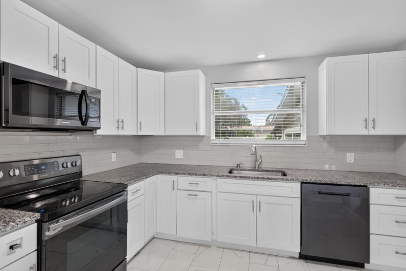 Kitchen with white cabinets and black appliances at 217 Baisden Rd, Jacksonville, FL 32218