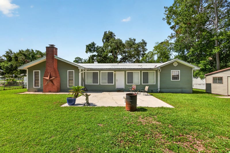 Side yard view with brick chimney and open lawn at 5843 Ovella Rd, Jacksonville, FL 32244