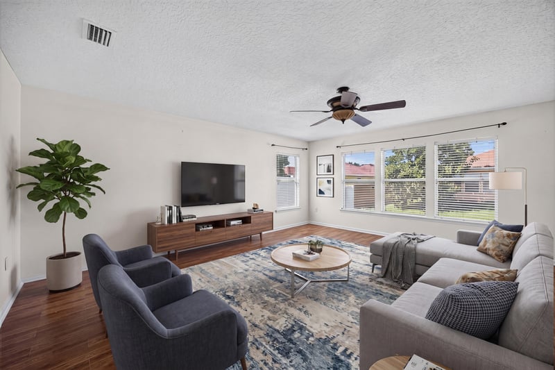 Virtually staged family room with sofa and TV at 2282 Justin Lake Dr, Jacksonville, FL
