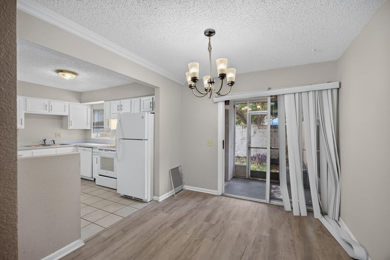 Kitchen with white cabinets and sliding glass door to the porch at 2658 Trollie Ln apt 1, Jacksonville, FL 32211
