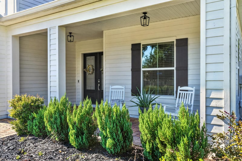 Front porch with rocking chairs and white columns at 22 Azura Point