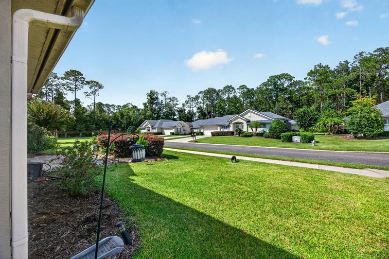 Side yard with lawn and street view at 2131 E Stone Creek Dr, Fleming Island, FL
