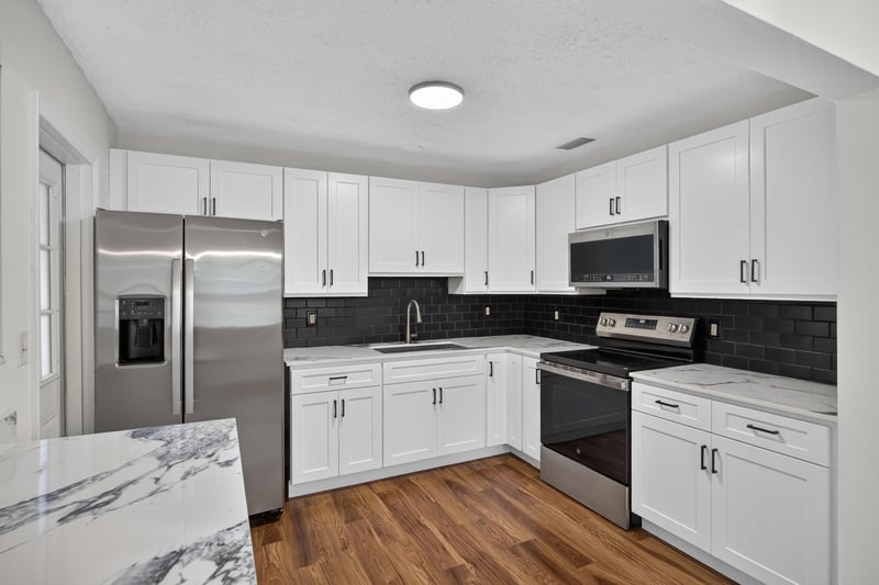 Kitchen with stainless fridge and black backsplash at 4039 Habana Ave, Jacksonville, FL