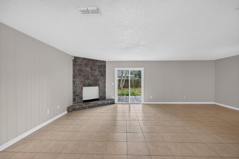 Living room with stone accent wall and sliding door at 1040 Willow Cove Ct E, Jacksonville, FL 32233