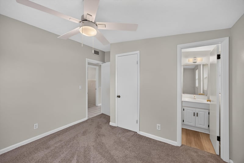 Carpeted bedroom leading to bathroom doorway at 87 Saratoga Cir S, Atlantic Beach, FL