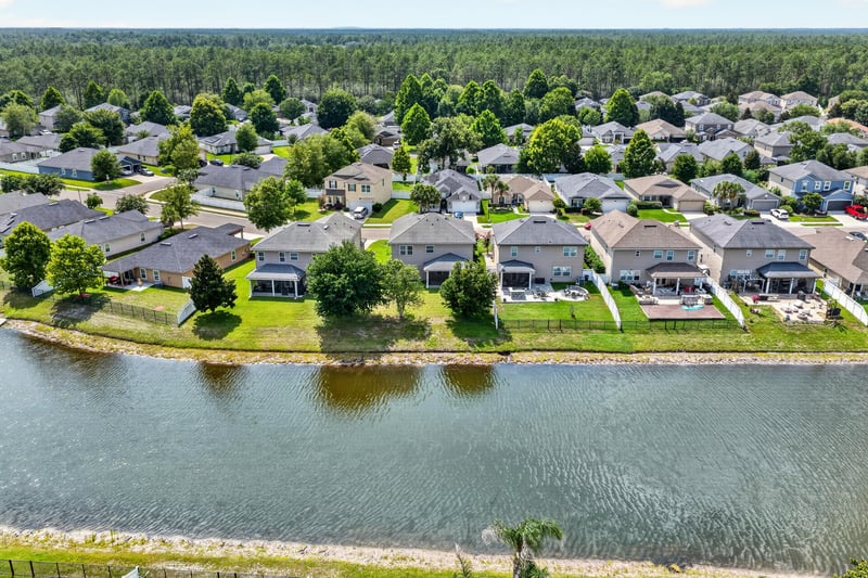 Drone view of neighborhood homes and retention pond in Orange Park, FL