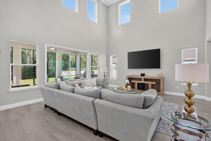 Living room with wall-mounted TV and sectional at 22 Azura Point