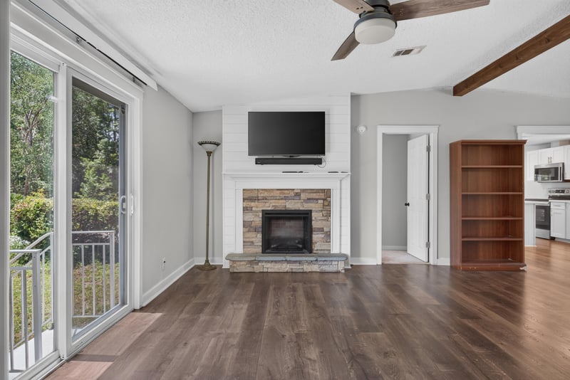 Living room with fireplace and glass doors to deck at 4890 McAllister Rd, Middleburg, FL 32068