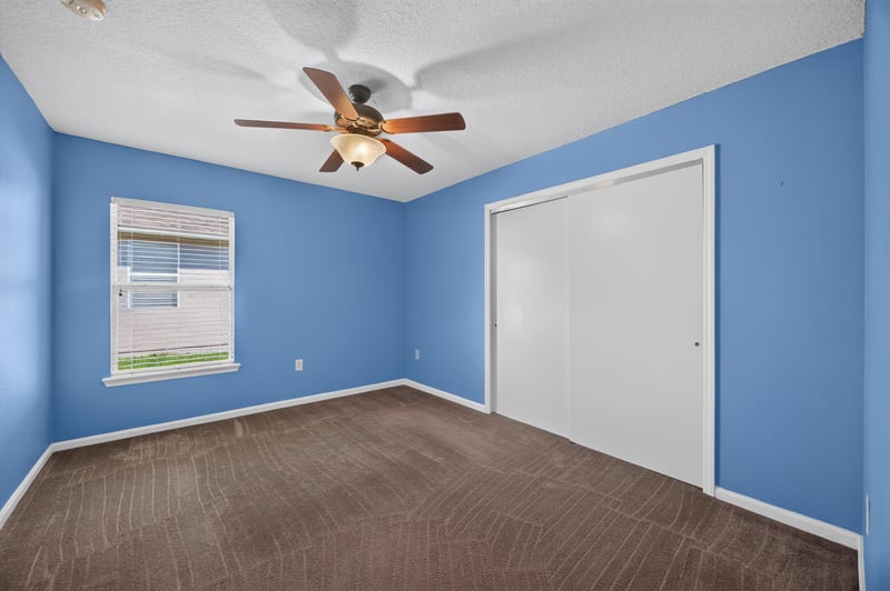Empty bedroom with blue walls and ceiling fan at 2282 Justin Lake Dr, Jacksonville, FL