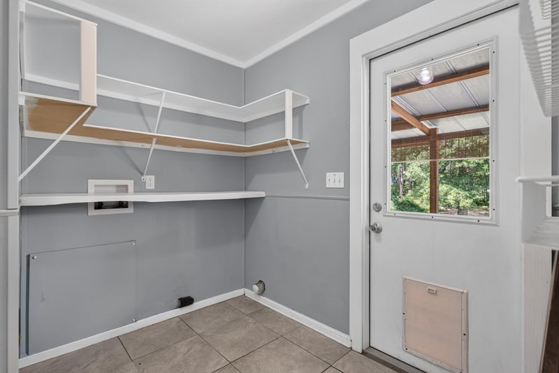 Laundry room with shelving and door to yard at 2549 Snapdragon Ave, Middleburg, FL 32068
