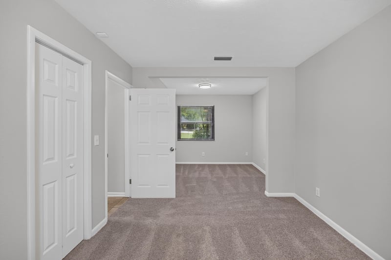 Bedroom with closet doors and carpet flooring at 7453 Jade Dr N, Jacksonville, FL 32210