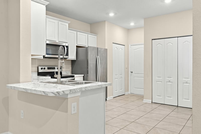 Kitchen with white cabinets, granite counters, and stainless appliances at 9555 Star Dr, Jacksonville, FL 32256