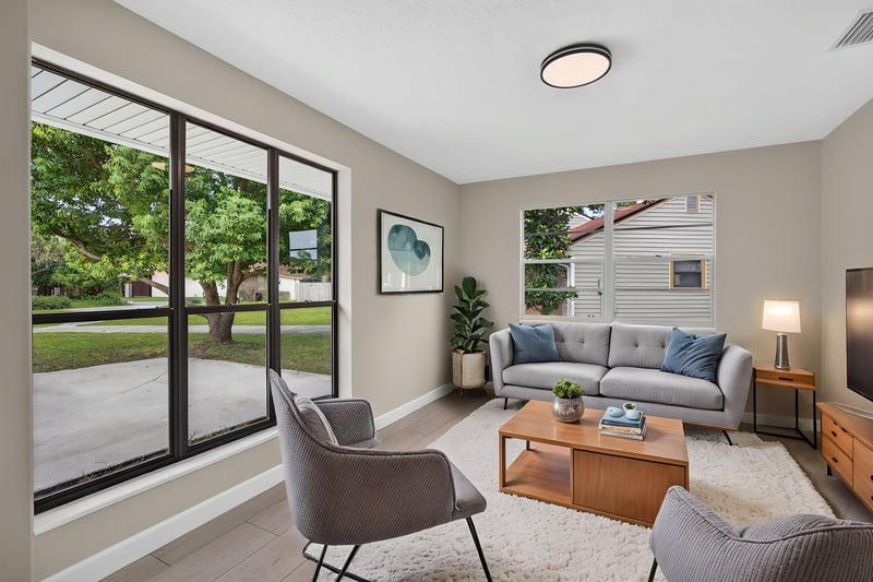 Living room with sliding glass doors and virtually staged seating at 4117 Wilcrest Ct, Jacksonville, FL 32277