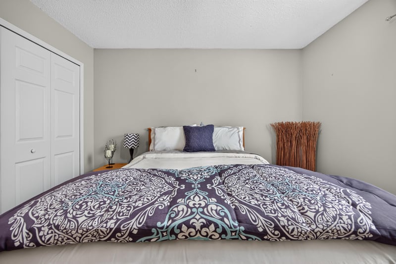 Bedroom with purple comforter and closet at 3067 Wavering Ln, Middleburg, FL 32068