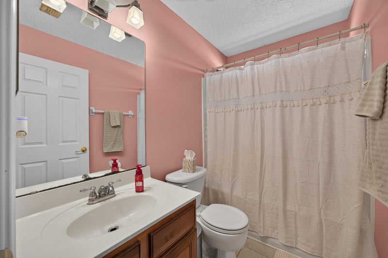 Bathroom with pink accent wall and tub-shower at 3660 Middlebrook Dr, Orange Park, FL 32065