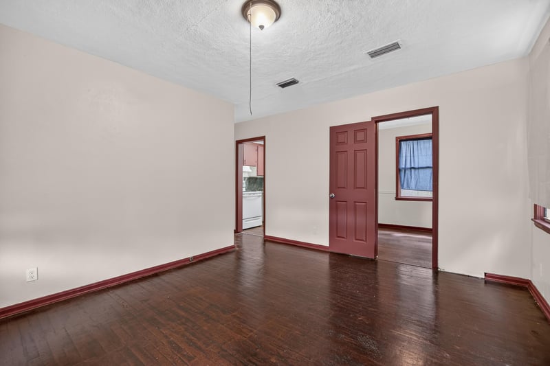 Empty room with red trim door and hardwood floor at 2132 Allandale Cir W, Jacksonville, FL