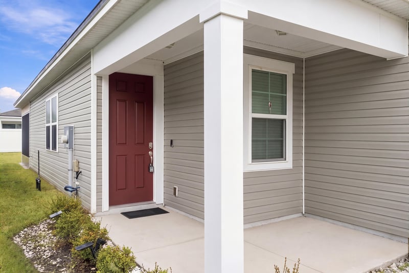 Front porch column and red front door at 7088 Mahogany Run Dr, Jacksonville, FL 32244