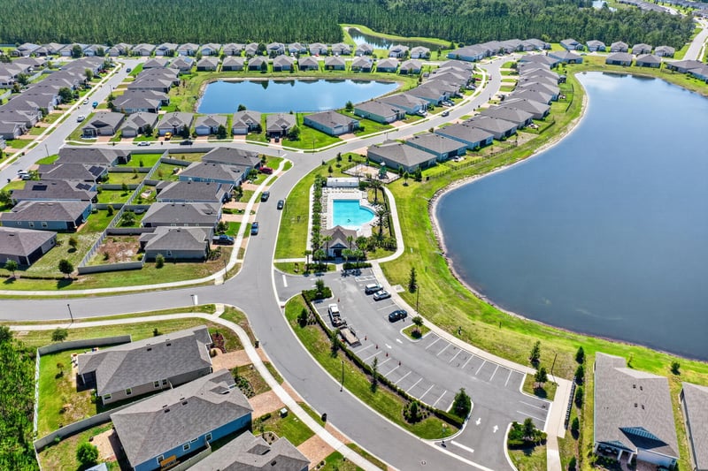 Drone view of community homes and lake in Highland Chase