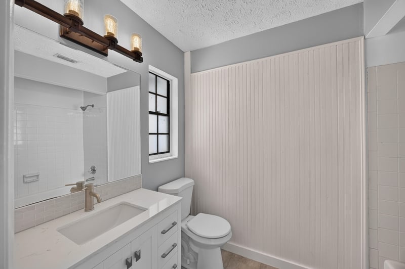 Bathroom vanity with white cabinetry and mirror at 6757 Deer Springs Rd, Keystone Heights, FL 32656