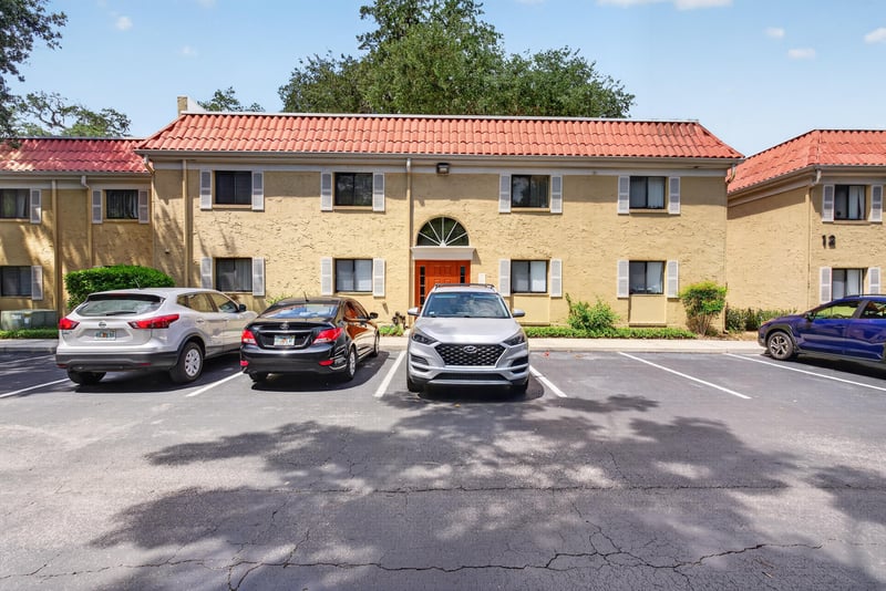 Condo building exterior with red tile roof and parking lot at 5811 Atlantic Blvd unit 47, Jacksonville, FL 32207