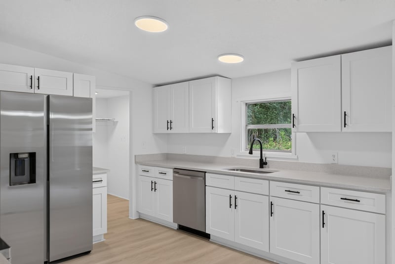 Kitchen with white cabinets and window over sink at 55520 Jewel-Thomas Rd, Callahan, FL 32011