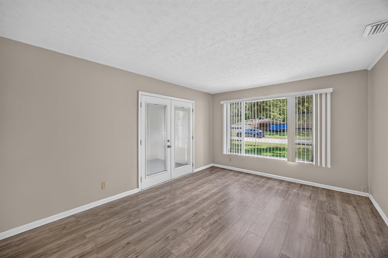 Living room with wood-look flooring and large windows at 5527 Beney Rd, Jacksonville, FL 32207