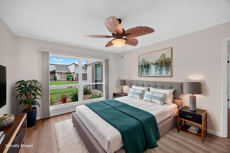 Staged bedroom with teal bedding and windows at 3407 Fairbanks Grant Rd N, Jacksonville, FL 32223