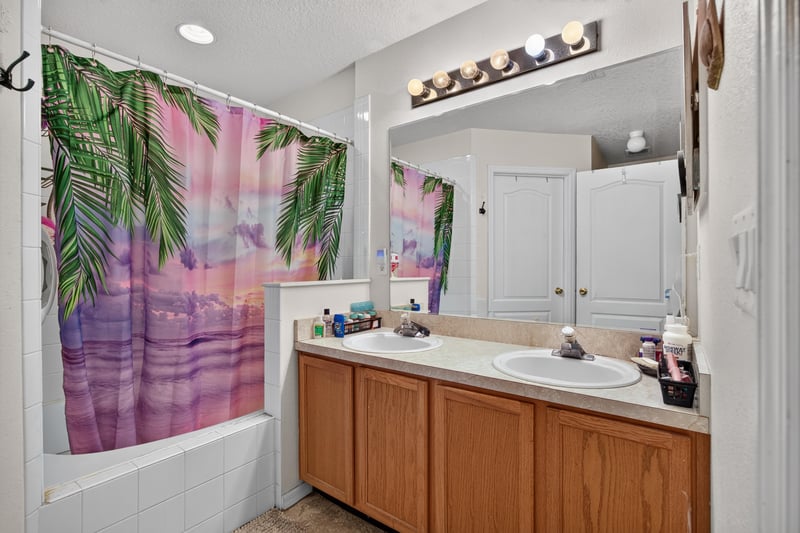 Bathroom with dual sinks and tropical shower curtain at 145 Dover Bluff Dr, Orange Park, FL