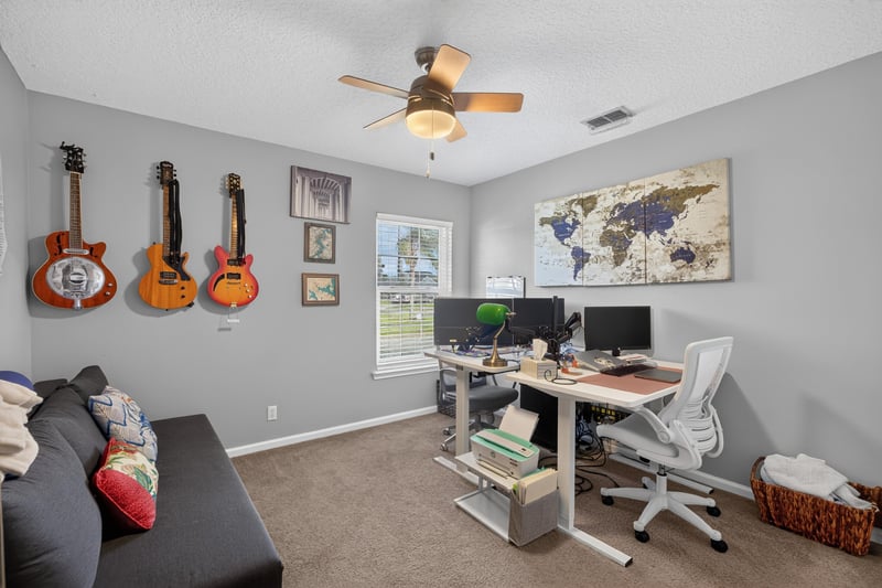 Bedroom used as office with guitars on wall at 12825 Kelsey Island Dr, Jacksonville, FL 32224